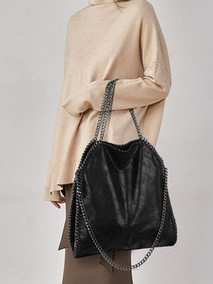 handbag in black featuring chain trim and relaxed fit