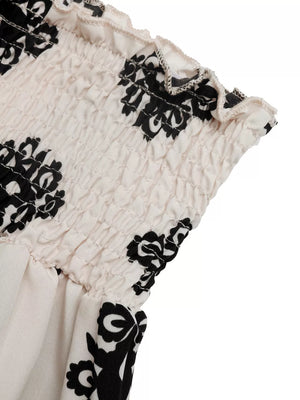 Loungewear shorts with smocked waist and black medallion print on apricot fabric.