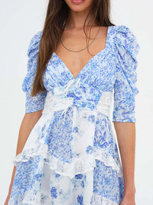 Sky blue floral ruched tie-front dress with puff sleeves and lace trim.