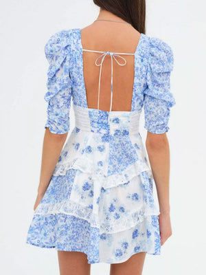 Sky blue floral tie-front dress with puff sleeves, open back, lace trim, and tiered skirt.