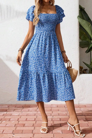 Blue floral smocked square neck midi dress with short puff sleeves and tiered skirt.