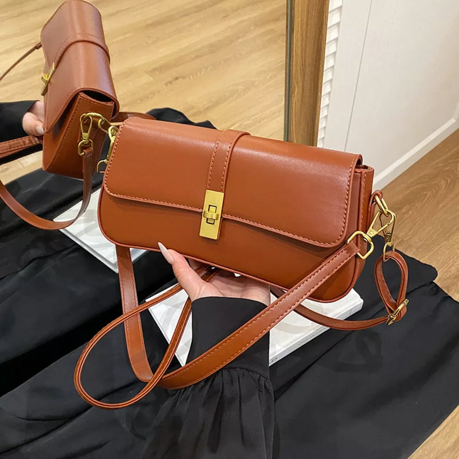 Brown rectangular crossbody bag with gold clasp and adjustable strap.