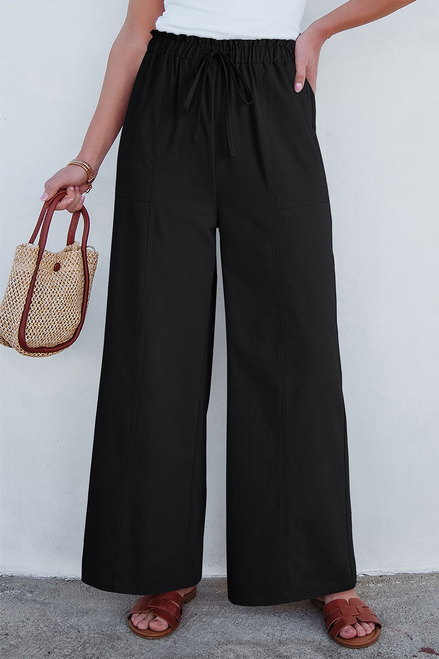Black cropped drawstring pants with elastic waist and wide legs.