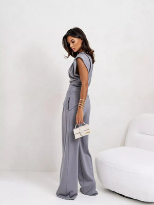 Gray satin cowl neck two-piece set with wide leg pants and a draped top.