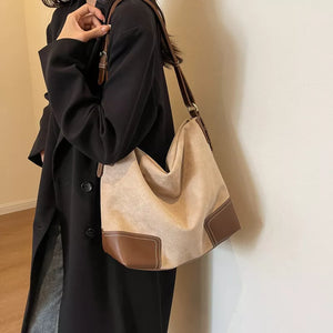 Khaki suede tote bag with brown leather accents and contrasting stitching.