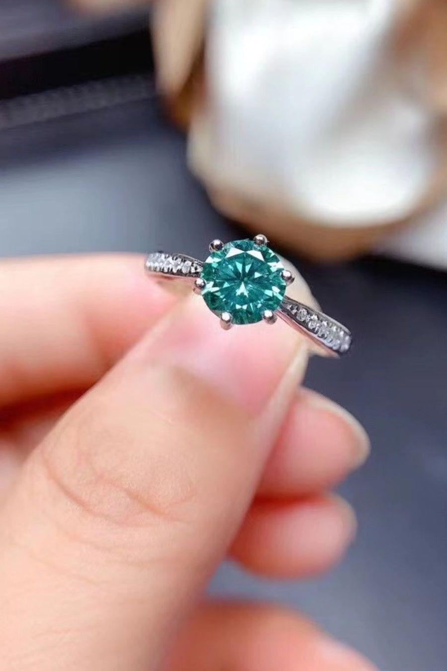 Teal moissanite solitaire ring with pave band in silver.