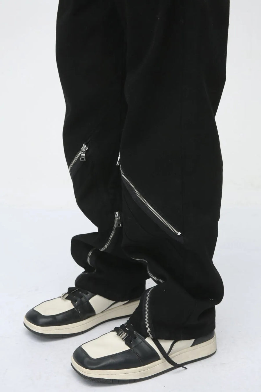 Dark straight leg jeans with multiple zip details on the legs.