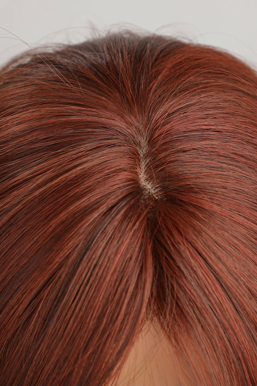 Layered copper red synthetic wig showing natural-looking scalp detail
