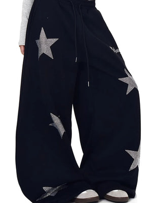 Black wide leg sweatpants with allover rhinestone star embellishments and drawstring waist.