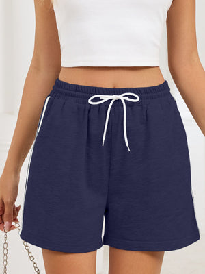Navy jogger shorts with drawstring and white sporty trim detail.