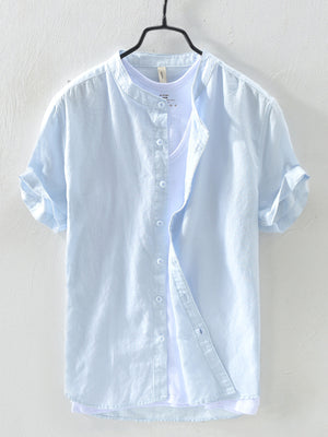 Light blue linen short sleeve henley shirt with rolled cuffs and button front.