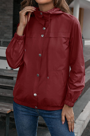 Burgundy hooded utility jacket with drawstring waist, snap buttons, and elastic cuffs.