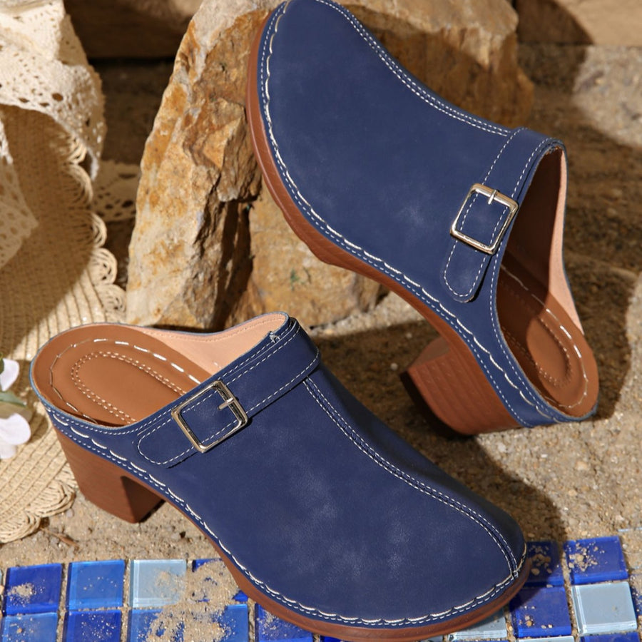 Blue round toe platform slip-on clogs with buckle detail and contrast stitching.