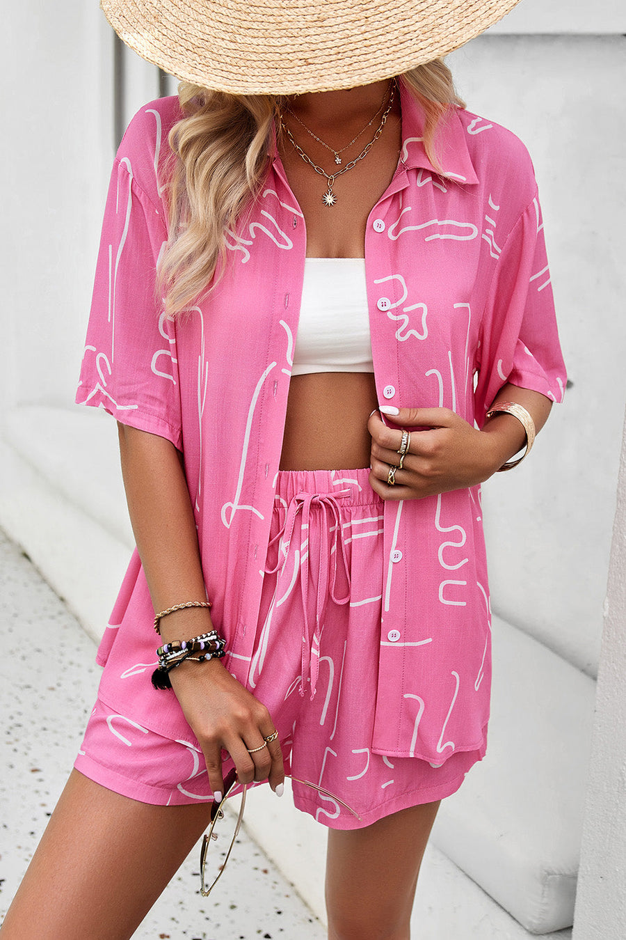 Pink abstract print resort shirt with button-down front and short sleeves, paired with matching shorts.