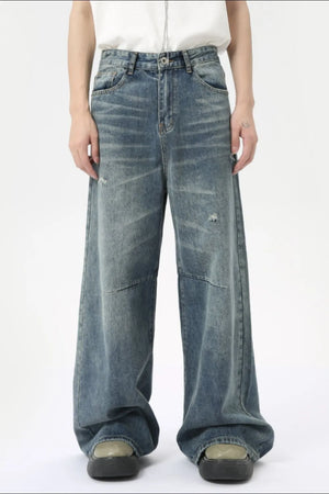 Oversized patchwork distressed denim trousers in medium wash cotton with a wide leg and casual styling.