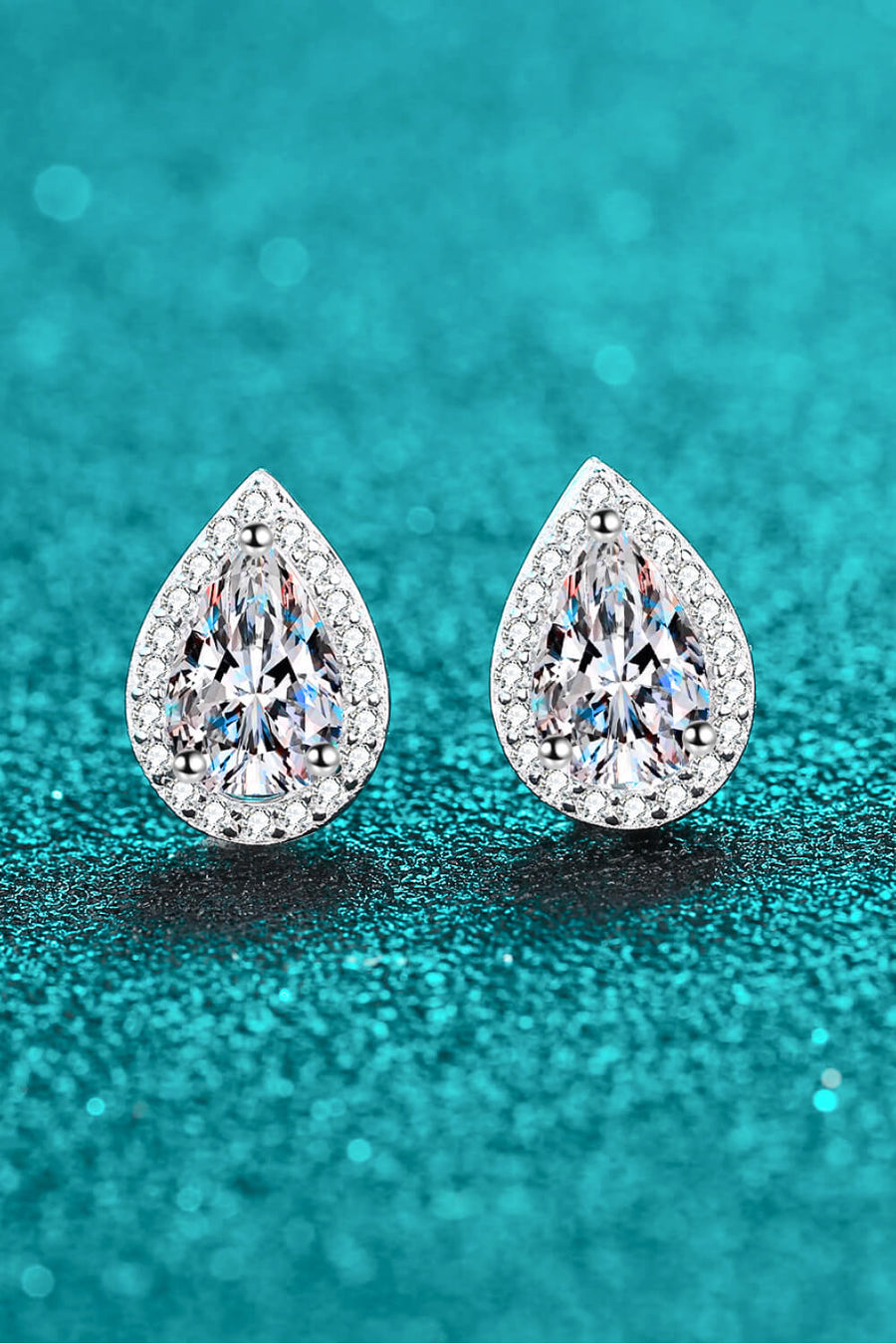 Silver teardrop halo earrings with pavé accents and a central faceted gem.