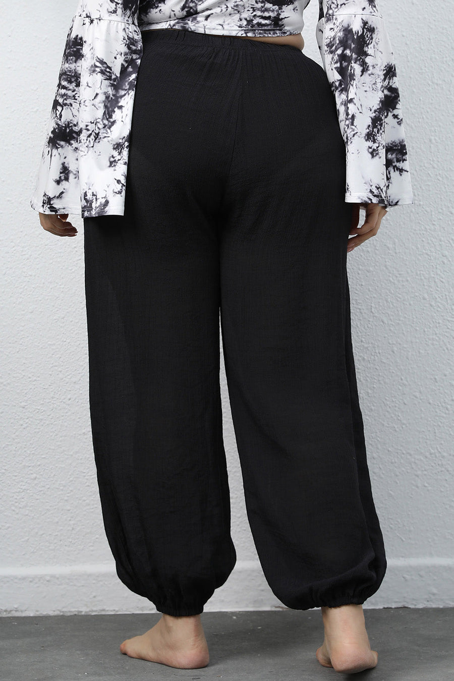 Black textured balloon-leg trousers with drawstring waist and elastic cuffs.