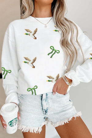 White pullover sweater featuring sequin embellishment and graphic print