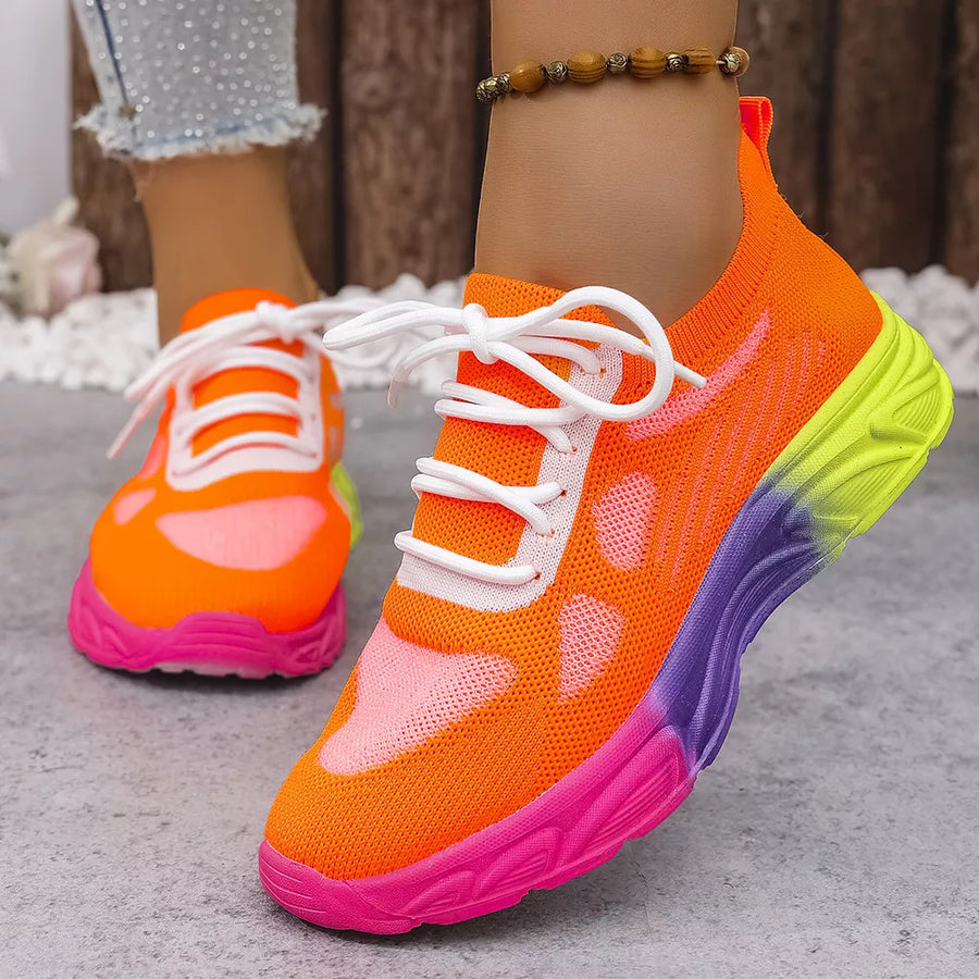 Orange red mesh lace-up sneakers with a pink, purple, and yellow gradient sole.