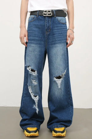 Distressed palazzo jeans in medium wash denim with wide legs and ripped details.