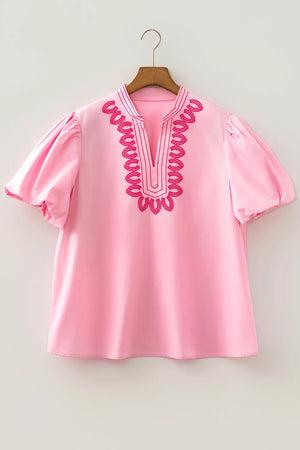 Pink cotton shirt with puff sleeves and contrast embroidery detail at neckline.