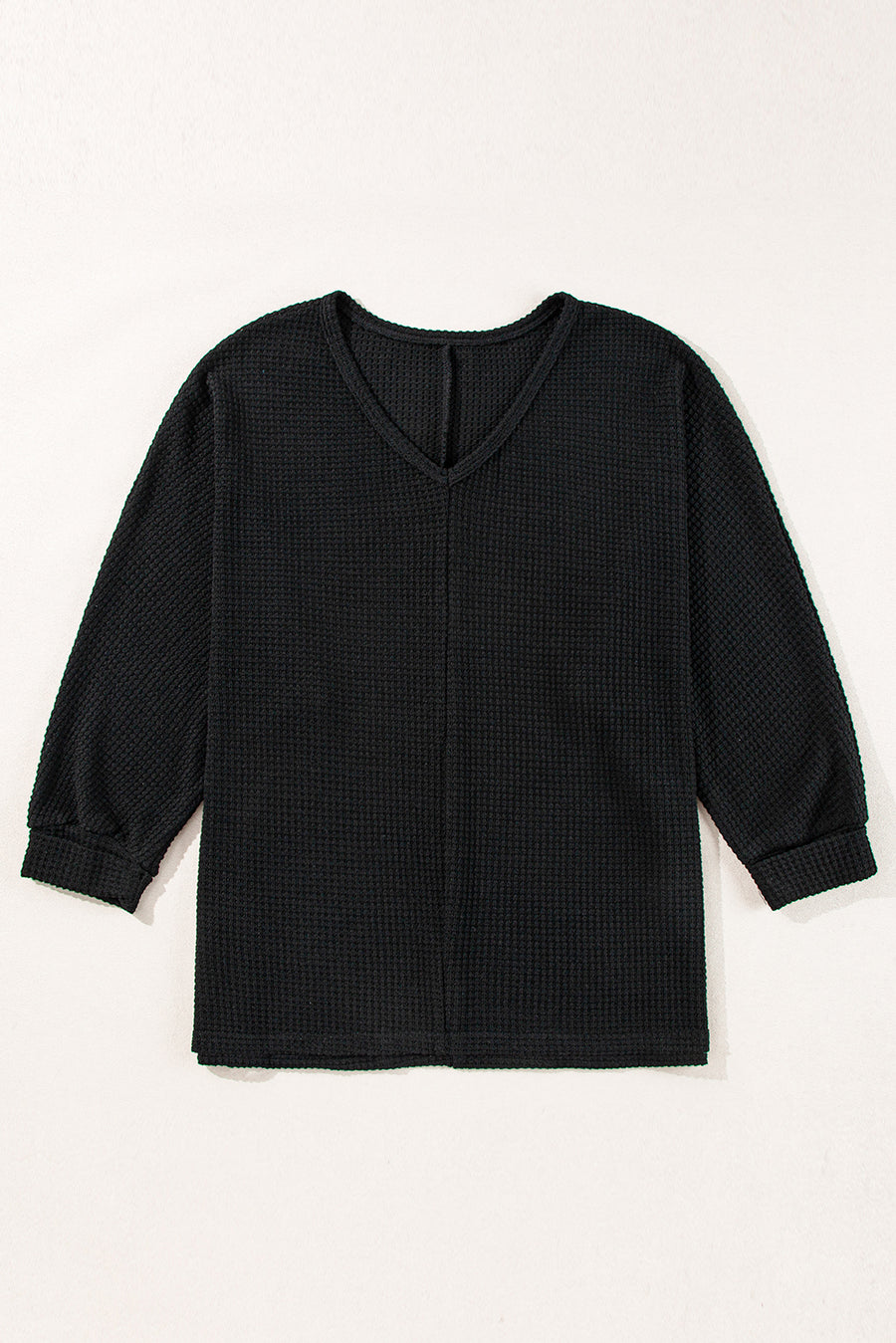 Black waffle knit V-neck long sleeve top with slit hem detail.