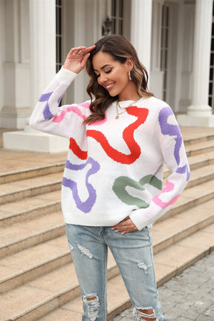 White crewneck sweater with abstract swirl pattern in red, purple, pink, and green.