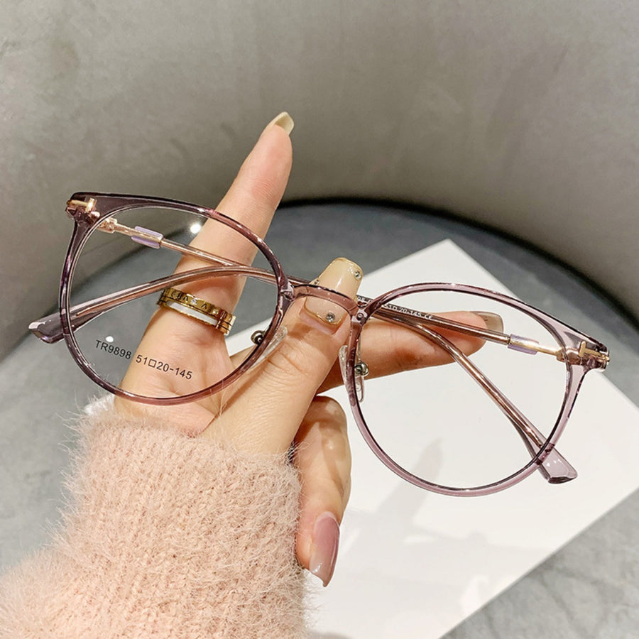 Translucent round frame eyeglasses in a muted purple hue with gold accents.