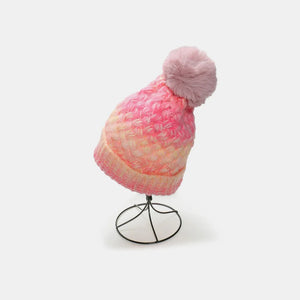 Textured ombre knit beanie with pink and yellow gradient and fluffy pom pom.