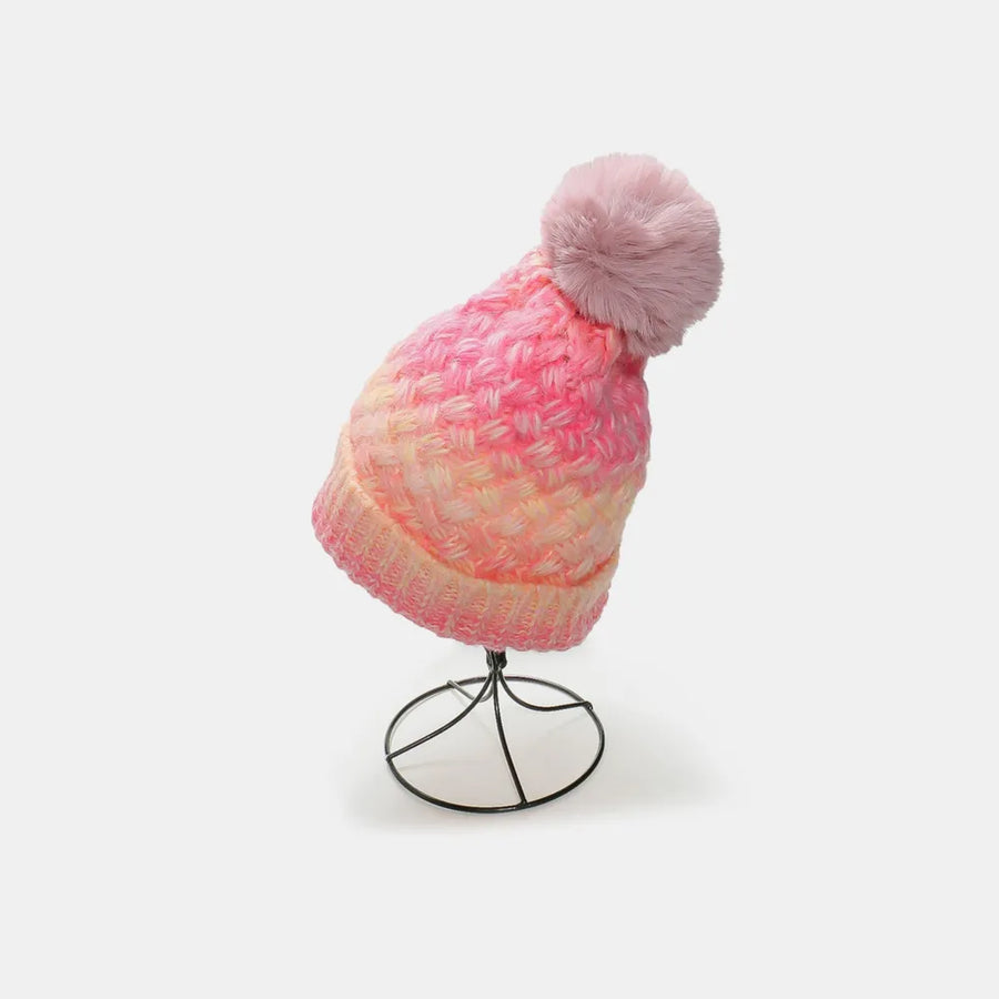 Textured ombre knit beanie with pink and yellow gradient and fluffy pom pom.