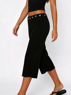 Black flared hem capri pants with button detail at the waist