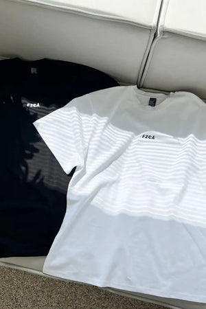 Oversized white and black t-shirts with drop shoulders and small chest logos.