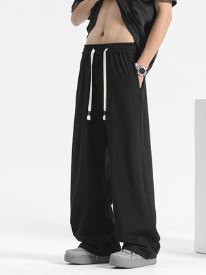 Black casual drawstring pants with a loose fit and wide leg.