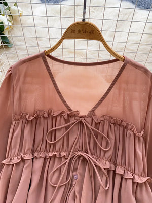 Apricot chiffon blouse with ruffled tie-front and V-neckline.