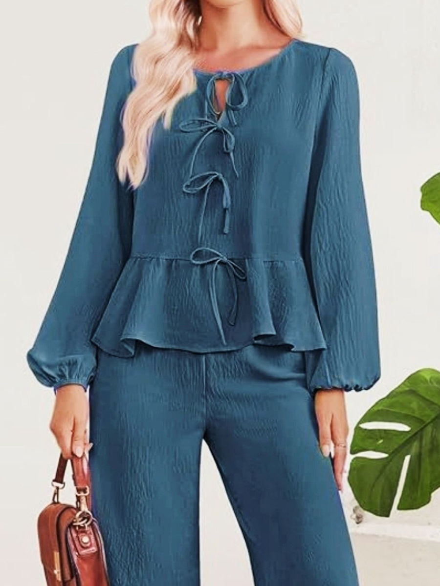 Blue textured peplum top with tie neck and long sleeves