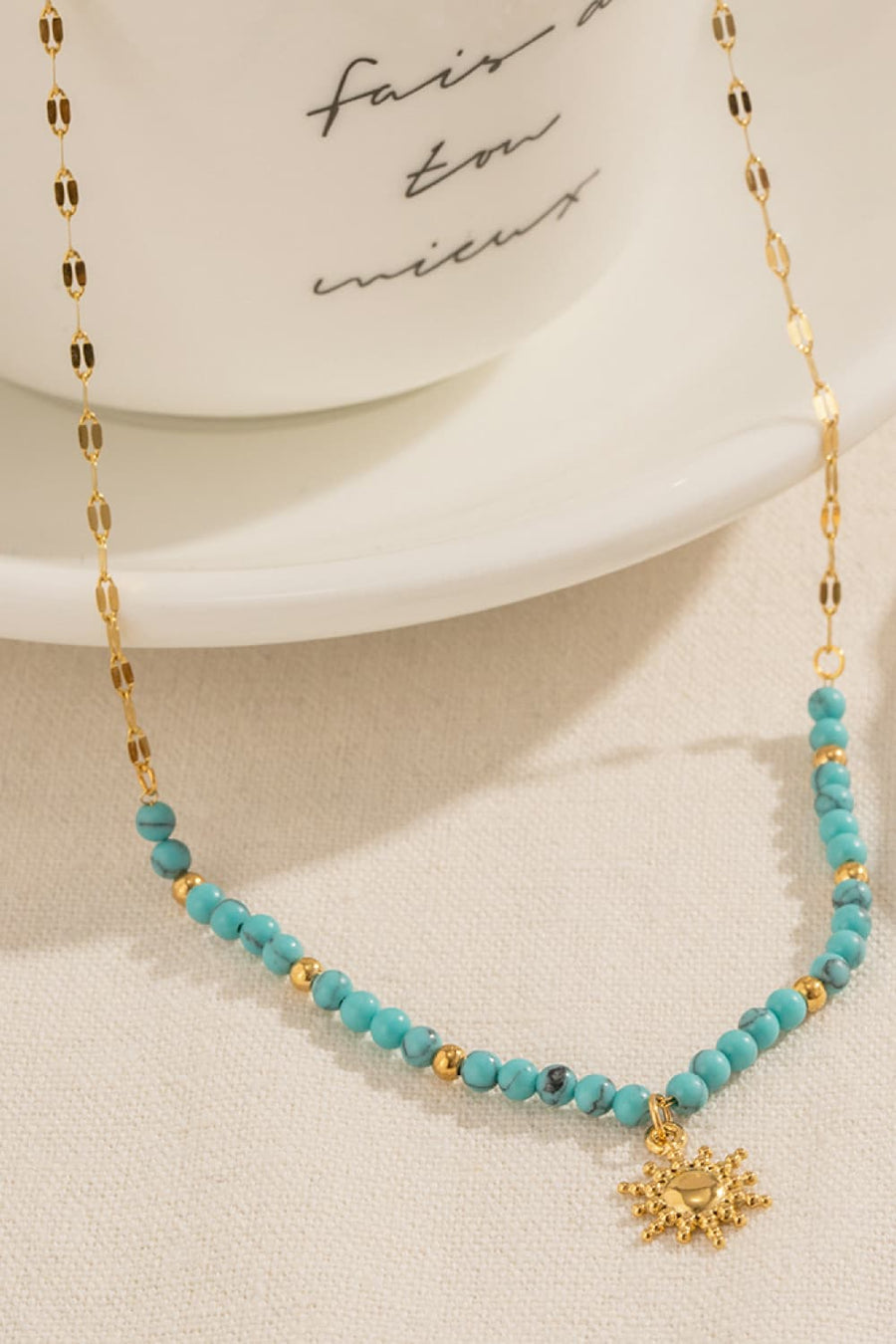 Gold celestial sunburst beaded necklace with turquoise and gold beads