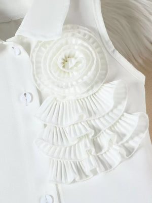 White ruffled applique top with decorative buttons and a collared neckline.
