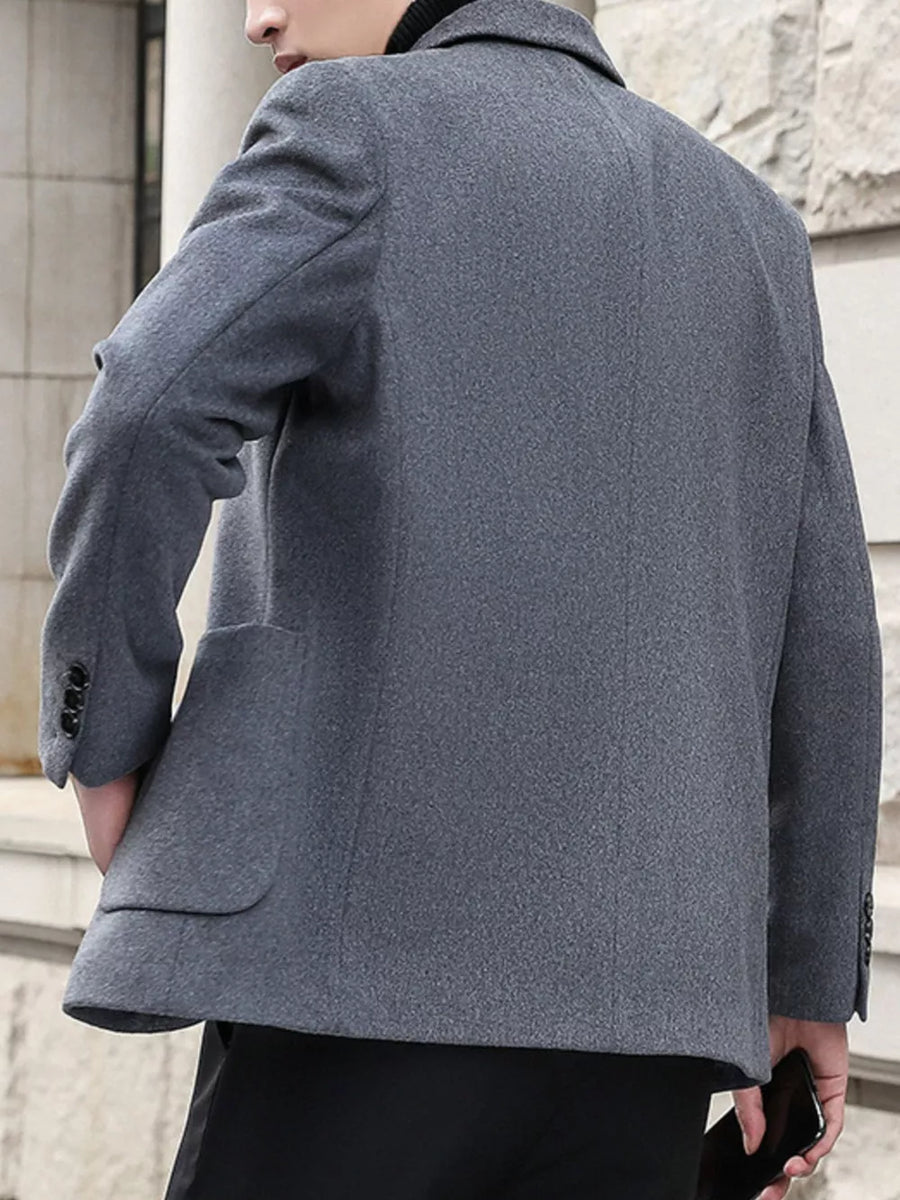 Men's grey lapel collar blazer with buttoned cuffs and flap pockets.
