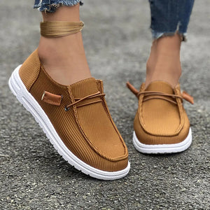 Caramel corduroy boat shoes with lace detail and white soles.