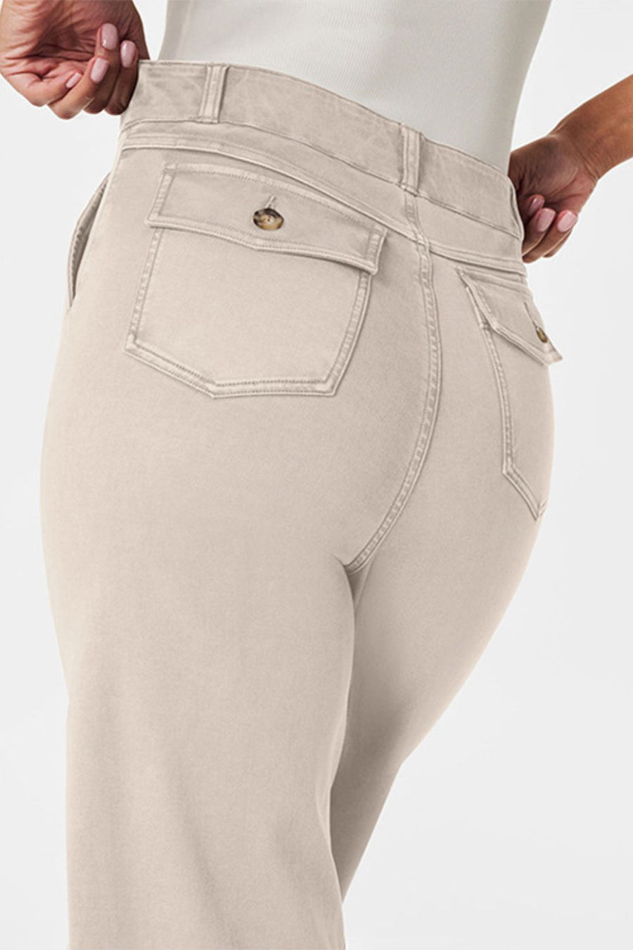 Tan wide-leg utility denim trousers with buttoned back pockets and a high waist.