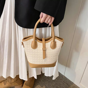 tan handbag featuring top handle and houndstooth