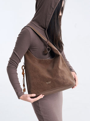handbag in dark brown with decorative tassel and large