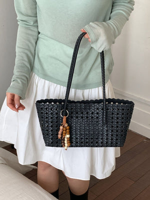 Black shoulder bag featuring woven design and woven