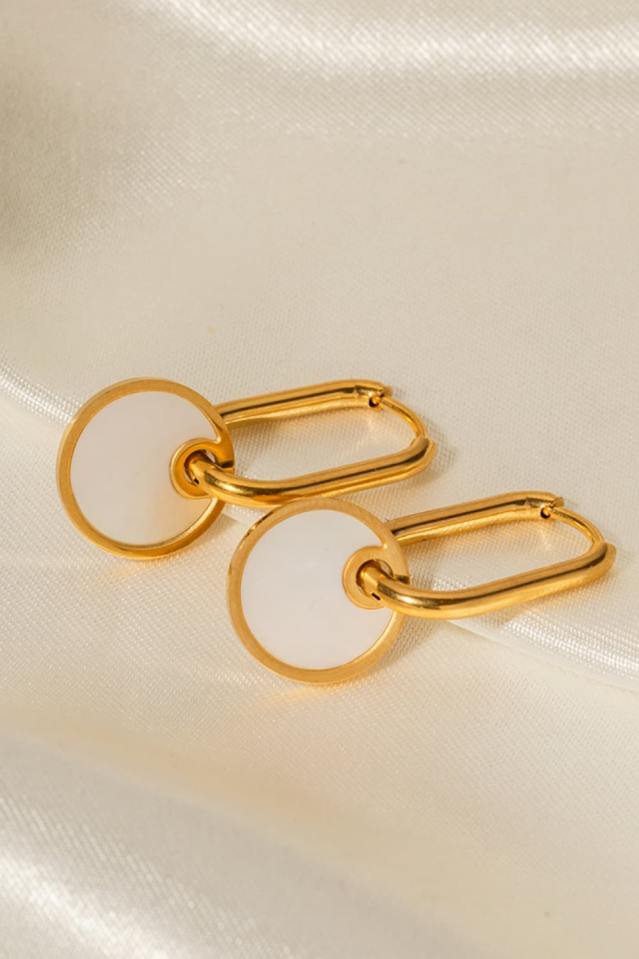 Gold mother-of-pearl disc drop earrings with oval links.