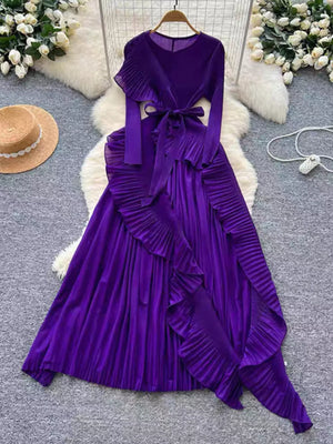 Purple midi dress with pleated skirt, ruffled asymmetrical hem, and tie waist.