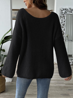 Black knit sweater with off-shoulder boatneck and balloon sleeves.