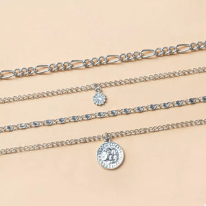 Layered silver necklaces with coin and starburst pendants