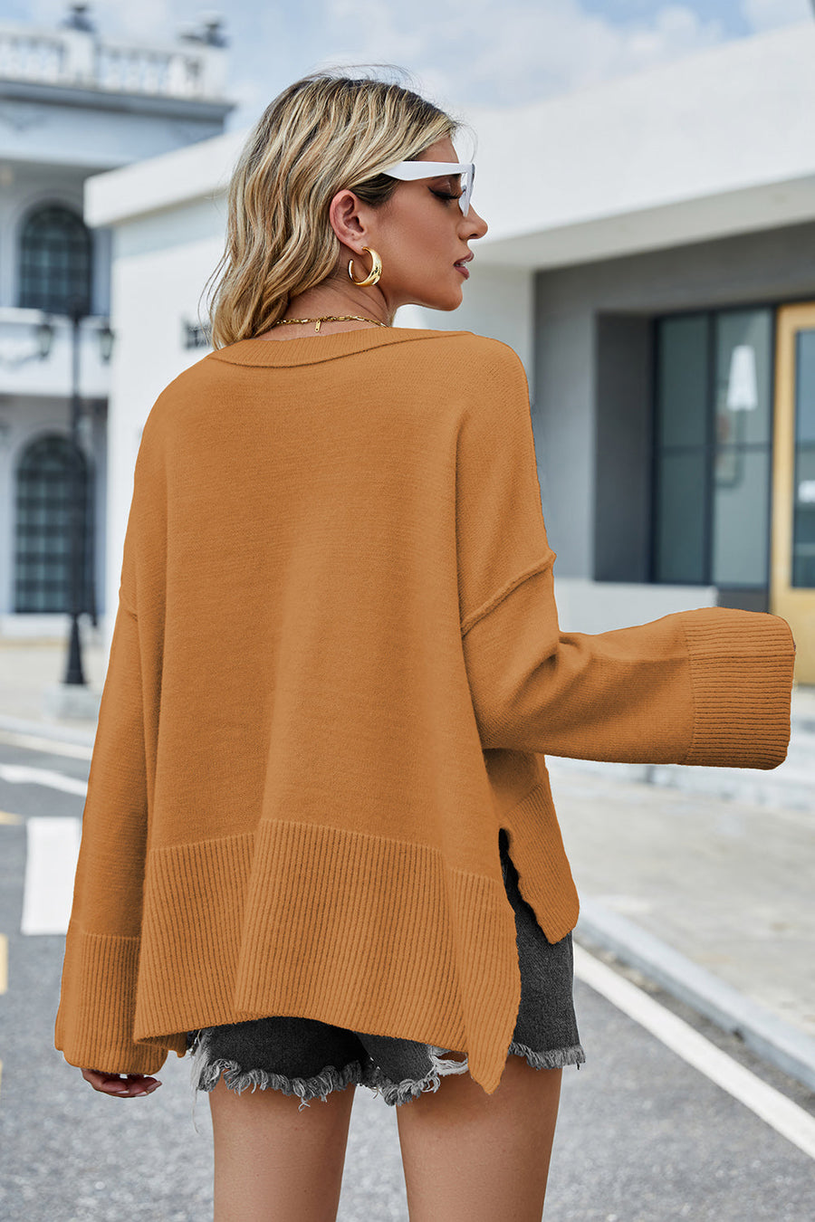 Ochre acrylic knit sweater with flared sleeves and split hem detail.