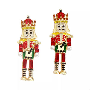 Whimsical nutcracker dangle earrings in red and gold with pearl accents.