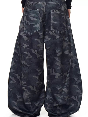 Men's baggy jeans in dark camouflage print with white stitching and back pockets.
